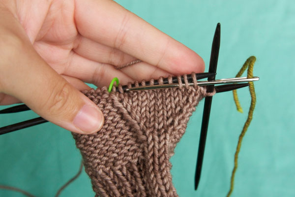 Run the needle through all of the thumb stitches