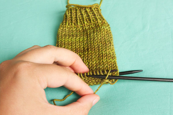 Insert the right needle into the first stitch on the left needle as if to purl