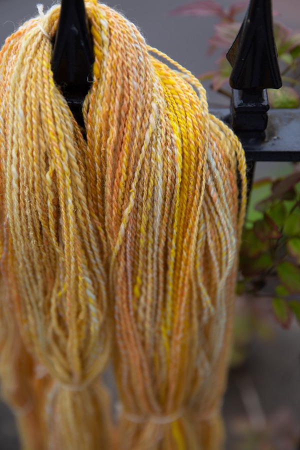A skein of yellow, white, pink handspun 2-ply